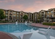 Thumbnail 33 of 34 - A resort-style swimming pool with lounge chairs at Aspen Ridge 55+ Active Adult Community