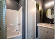 Thumbnail 8 of 18 - A bathroom with a white tub and sink.
