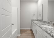 Thumbnail 8 of 36 - a bathroom with white cabinets and granite counter tops and a bath tub and a sink at Hillcrest Village, Springdale, AR 72762