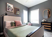 Thumbnail 1 of 18 - A bedroom with a large bed and a mirror on the wall.