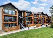 Thumbnail 19 of 19 - Apartment complex with wooden exteriors and black railings.