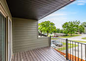 Thumbnail 7 of 19 - A balcony with a black railing and a brown floor.