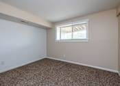 Thumbnail 12 of 19 - A room with a window and carpeted floor.