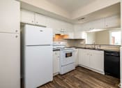 Thumbnail 3 of 19 - A white refrigerator is in a kitchen with wooden floors.