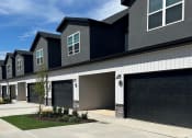 Thumbnail 3 of 36 - townhome with two garage doors and a sidewalk in front of it at Hillcrest Village, Springdale, 72762