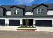 Thumbnail 11 of 36 - a house with black garage doors and a black roof at Hillcrest Village, Springdale Arkansas