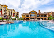 Thumbnail 8 of 59 - A large swimming pool in front of a resort-style building.