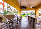 Thumbnail 9 of 59 - A patio with a stone wall and a grill.