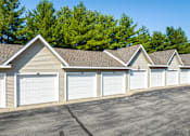 Thumbnail 37 of 44 - A row of garages with trees in the background.