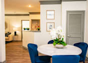 Thumbnail 50 of 50 - A dining room with a round table and blue chairs.