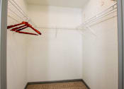 Thumbnail 42 of 50 - A white closet with a red hanger and a brown carpet.