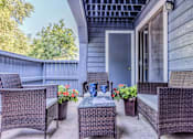 Thumbnail 34 of 34 - A patio with a table and chairs and a vase of flowers.