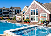 Thumbnail 11 of 53 - a swimming pool with an apartment building in the background  at Waterside Residences on Quivira, Lenexa, KS, 66215