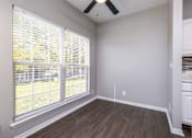 Thumbnail 16 of 28 - A room with a window covered by white blinds and a ceiling fan.