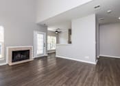 Thumbnail 17 of 28 - A spacious living room with wood flooring and a fireplace.