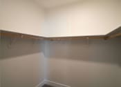 Thumbnail 8 of 18 - A white closet with a light shining through the door.