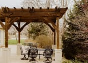 Thumbnail 15 of 23 - a wooden pergola with a table and chairs under it