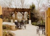 Thumbnail 14 of 23 - a backyard patio with a wooden pergola and chairs