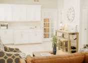 Thumbnail 7 of 23 - a living room and kitchen with a large clock on the wall