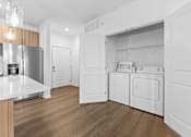 Thumbnail 53 of 53 - A modern kitchen with a refrigerator, oven, and washing machine.