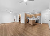 Thumbnail 52 of 53 - A spacious room with wooden flooring and a kitchen area in the background.