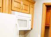 Thumbnail 19 of 23 - a kitchen with white appliances and wooden cabinets