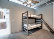 Thumbnail 6 of 15 - a bunk bed in a room with a ceiling fan
