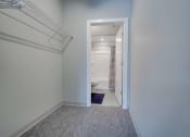 Thumbnail 10 of 15 - a long hallway with a door to a bathroom and a hallway mirror with a closet