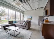 Thumbnail 5 of 15 - a living room with a couch and a coffee table in front of a large window