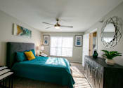 Thumbnail 22 of 25 - A bedroom with a bed, a dresser, and a mirror.