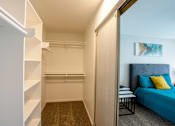Thumbnail 23 of 25 - A bedroom with a blue bed and a painting on the wall.