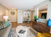 Thumbnail 8 of 25 - A living room with a couch, a coffee table, and a mirror.