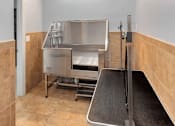Thumbnail 20 of 50 - A clean, empty kitchen with a stainless steel sink and a black conveyor belt.