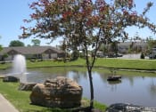 Thumbnail 3 of 23 - a pond with a fountain in front of a house