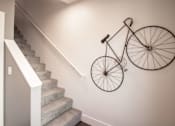 Thumbnail 15 of 18 - A bicycle is mounted on the wall above a staircase.
