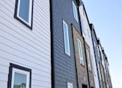 Thumbnail 17 of 18 - A building with alternating white and dark grey siding.