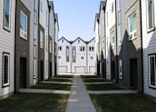 Thumbnail 15 of 18 - A long row of modern houses with white and brown exteriors.