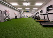 Thumbnail 12 of 18 - A gym with treadmills and exercise equipment.
