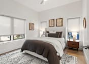 Thumbnail 1 of 12 - A bedroom with a large bed and a ceiling fan.