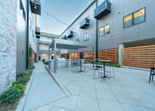 Thumbnail 2 of 12 - A patio area with a table and chairs is surrounded by a brick wall and a wooden fence.