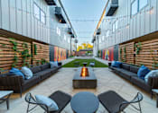 Thumbnail 7 of 12 - A patio with a fire pit and seating area.