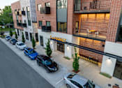 Thumbnail 8 of 12 - A street view of a building with cars parked in front of it.