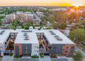 Thumbnail 5 of 12 - A sunset view of a modern apartment complex.