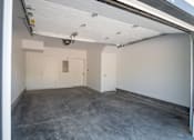 Thumbnail 11 of 18 - A large empty room with white walls and a concrete floor.