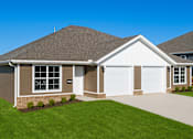 Thumbnail 14 of 15 - A house with a brown roof and a white garage door.