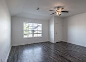 Thumbnail 7 of 15 - A room with a ceiling fan and a window with blinds.