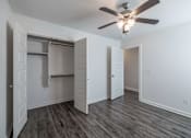 Thumbnail 6 of 15 - A room with a ceiling fan and a closet with a sliding door.