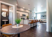 Thumbnail 5 of 18 - A modern kitchen with a round table and chairs.