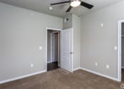 Thumbnail 23 of 37 - an empty room with a ceiling fan and a door to a closet