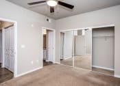 Thumbnail 30 of 37 - an empty bedroom with mirrored closet doors and a ceiling fan